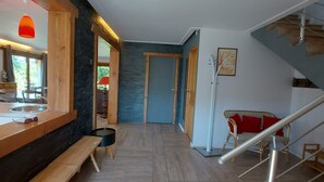 A hallway with a wooden bench, a small table, a wicker chair, and a staircase. - Morzine: panoramic, south-facing, comfortable chalet (Morzine)
