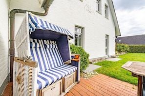 A white brick house with a patio area.