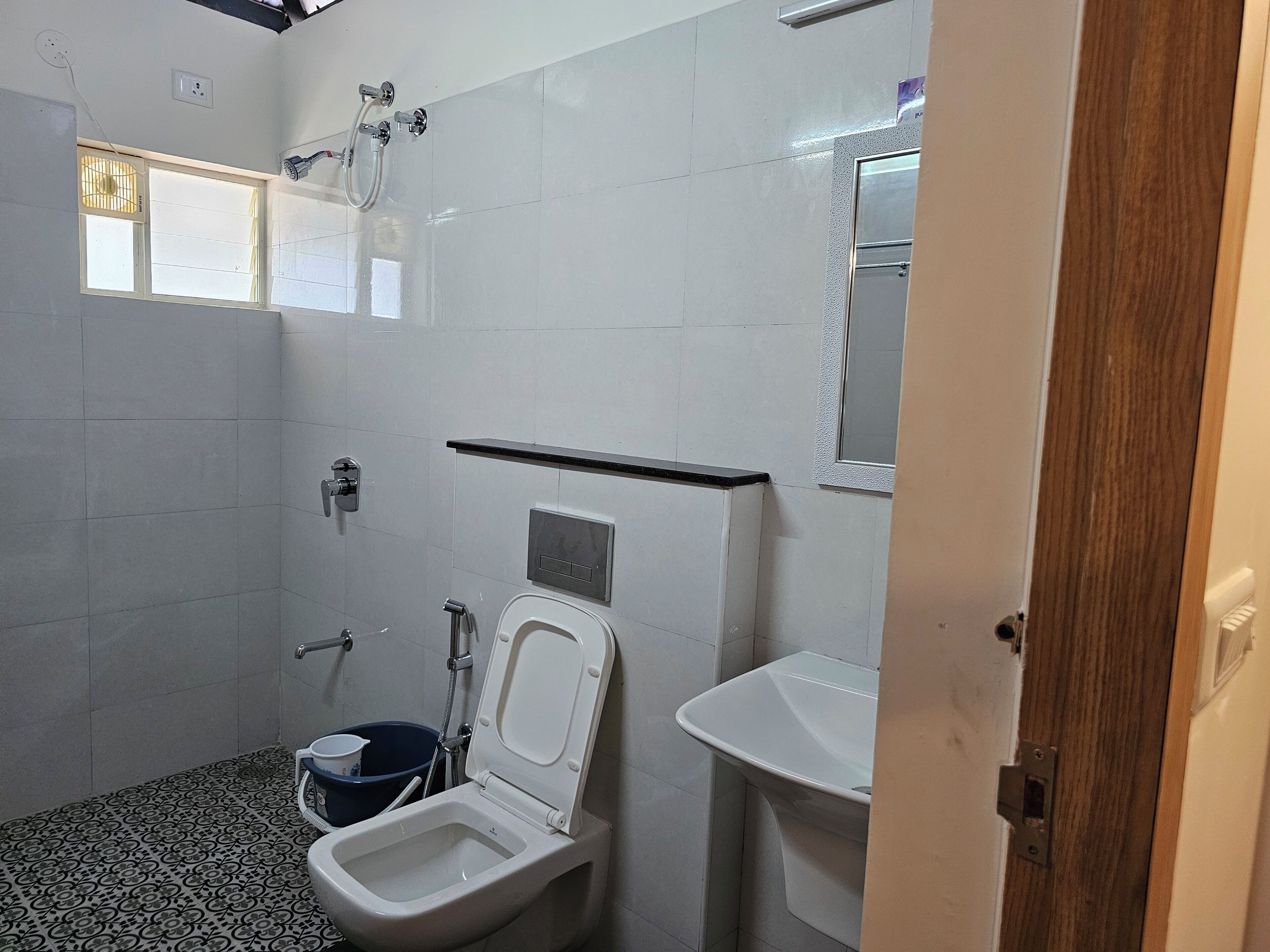 A bathroom with a toilet, bidet, and shower.
