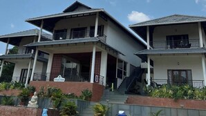A two-story building with a balcony and a staircase leading to the upper floor. - Hillock Vista Homestay by Aarika Resorts (Sakleshpur)