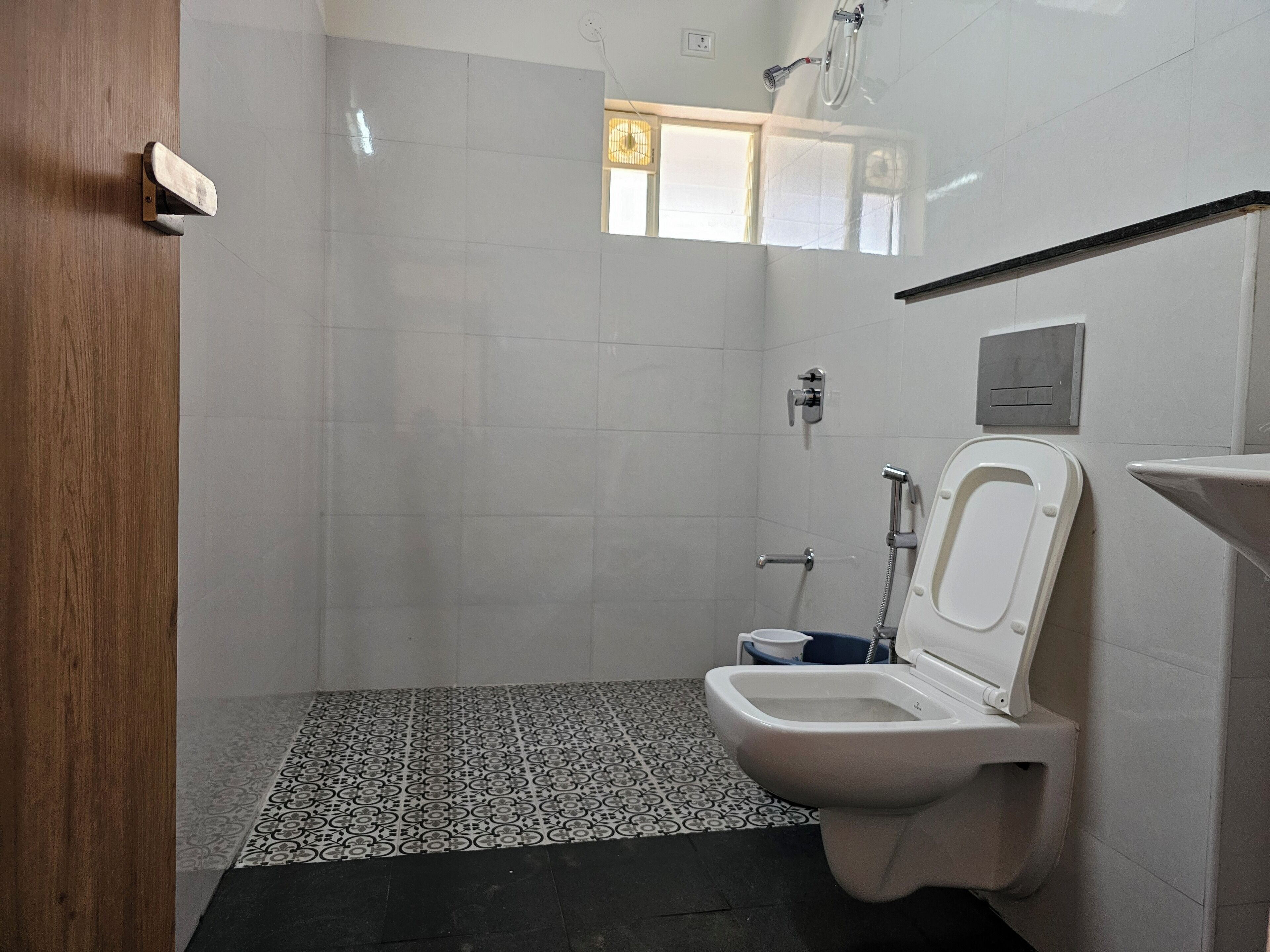 Une petite salle de bain propre, équipée de toilettes, d’une douche et d’un lavabo.