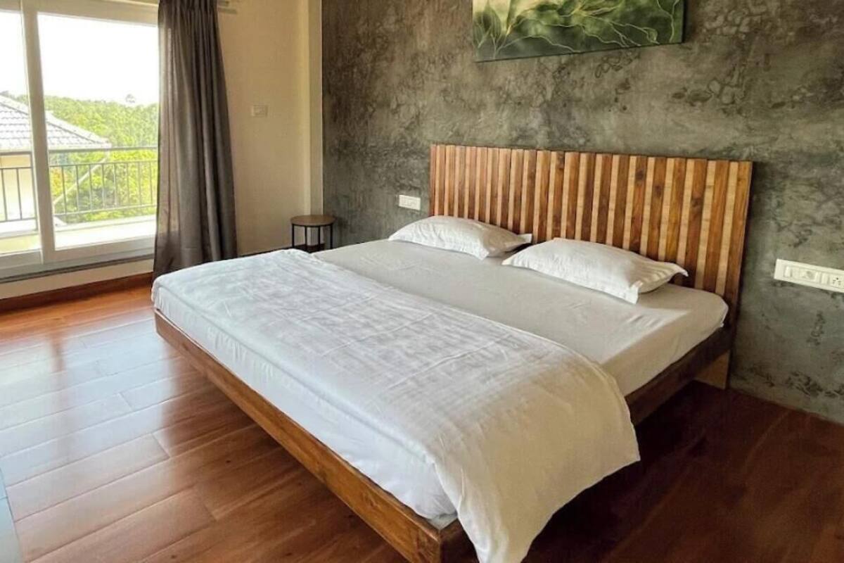 Un'ampia camera da letto con un letto grande, vista sull'esterno e una parete strutturata.