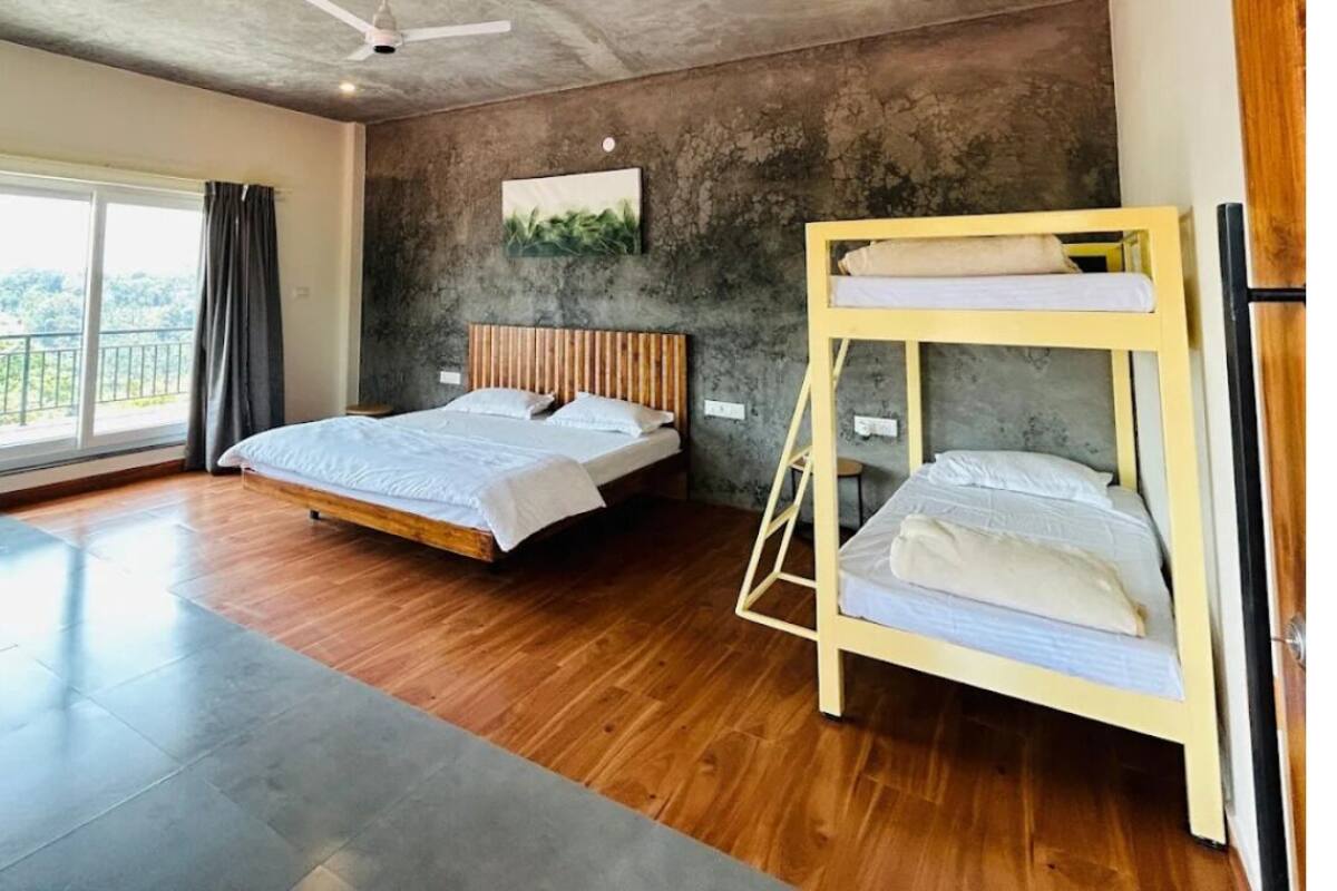 Una camera da letto con un letto a castello, una ventola a soffitto, un'ampia finestra e vista sull'esterno.