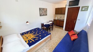 A compact room with a bed, a sofa, a dining table, and a kitchenette. - Studio Nadica (Šmrika)