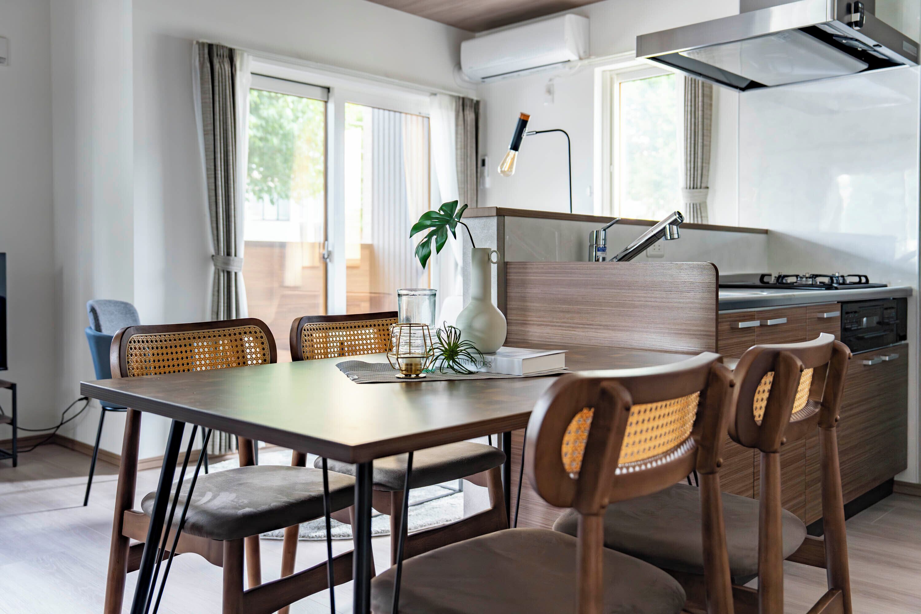 Una cocina moderna con comedor, que incluye una mesa de madera, sillas y una estufa empotrada.