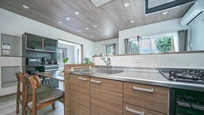 Une cuisine moderne avec des meubles en bois, un évier en acier inoxydable et une cuisinière intégrée.