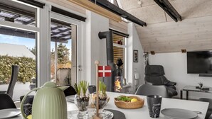 Un espace de restauration moderne avec une table dressée pour deux personnes, un drapeau et une cheminée.