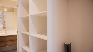 Une salle de bain avec un meuble-lavabo blanc, un miroir et un porte-serviettes.