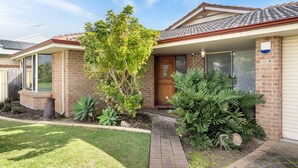 A residential house with a brick facade, a tiled roof, and a front yard with various plants. - Busselton by the Bay - plus Winter Giveaway (Busselton)