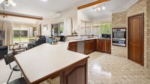 A spacious kitchen with a large island, wooden cabinets, and a built-in oven. - Busselton by the Bay - plus Winter Giveaway (Busselton)