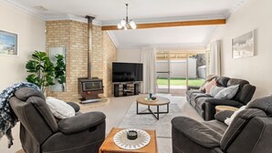 A living room with a fireplace, a television, and a sofa set. - Busselton by the Bay - plus Winter Giveaway (Busselton)