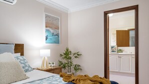 A bedroom with a bed, bedside table, lamp, and a large mirror. - Busselton by the Bay - plus Winter Giveaway (Busselton)