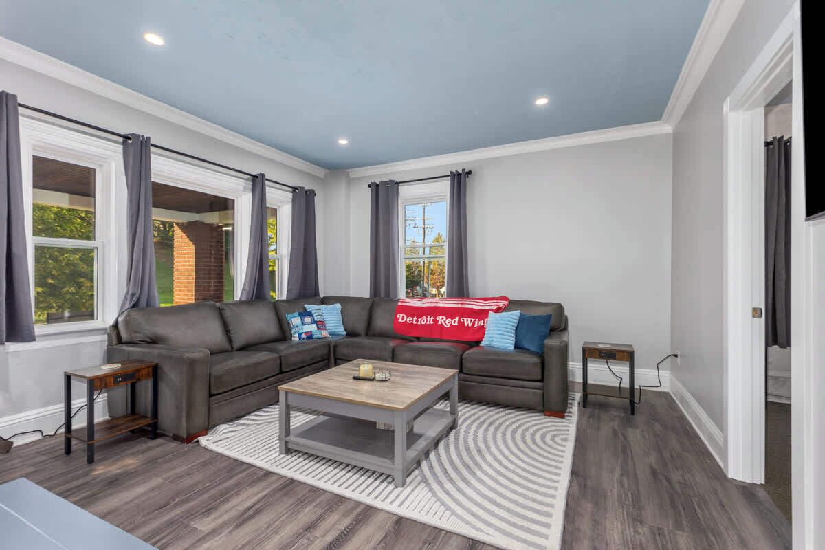 A modern living room with a sectional sofa, a coffee table, and a patterned rug.