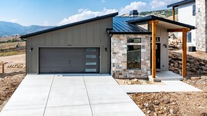 Ein modernes Einfamilienhaus mit Garage, Steinaußenwand und überdachter Veranda.