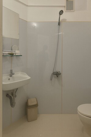Economy vierpersoonskamer | Badkamer | Een douche, gratis toiletartikelen, een haardroger, handdoeken
