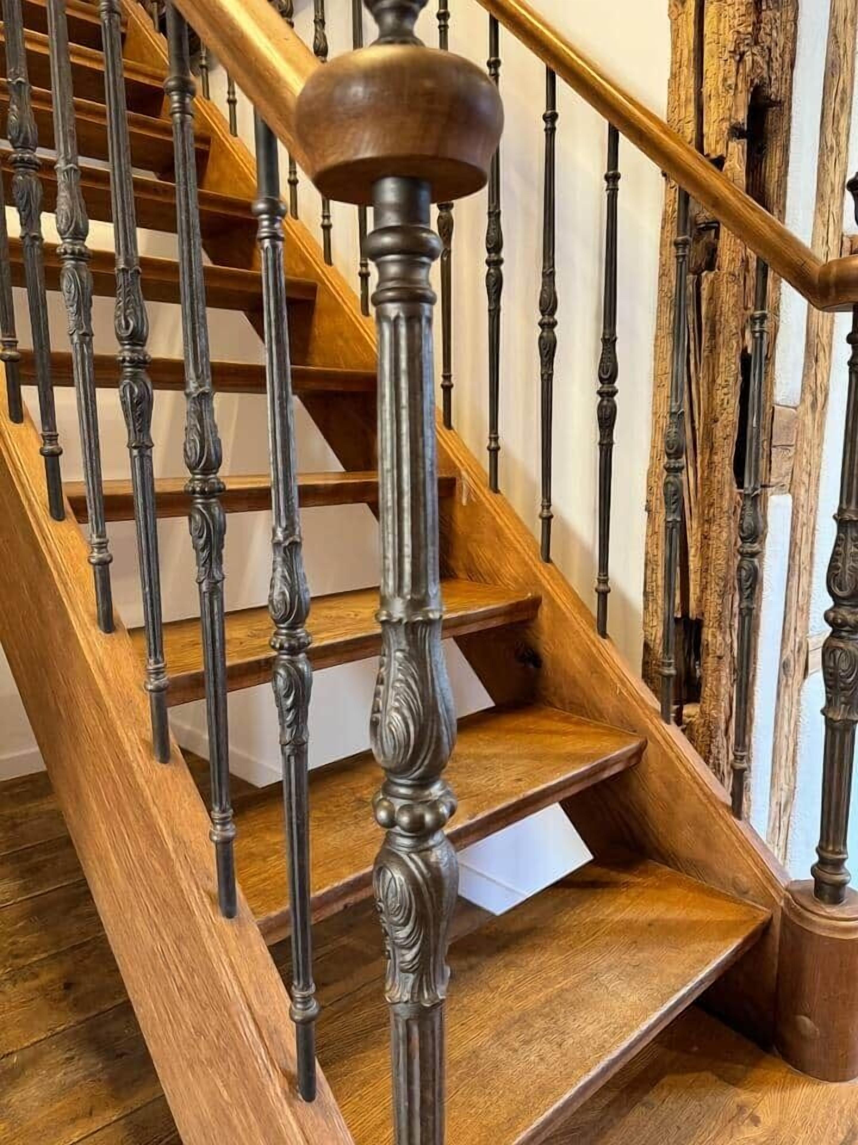Una escalera de madera con barandillas ornamentales y pasamanos de madera.