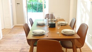 Comedor con una mesa de madera dispuesta para cuatro personas, rodeada de cuatro sillas.