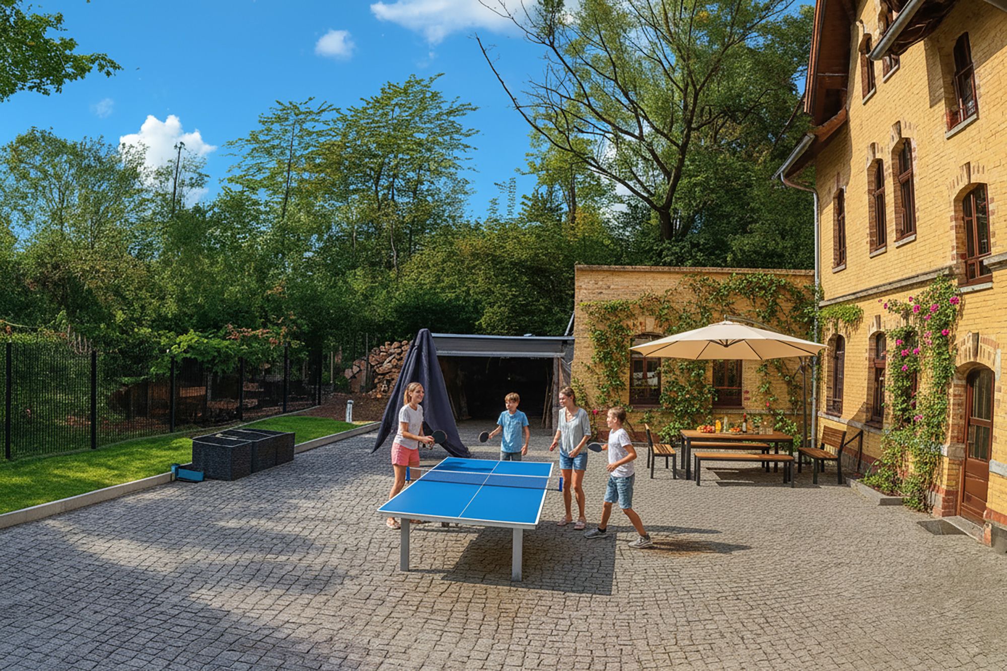 Ein Außenbereich mit Tischtennisplatte, überdachter Sitzgelegenheit und einem Garten an einem Backsteinhaus.