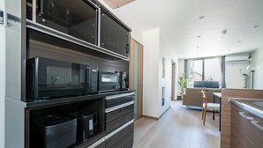 Una cocina moderna con electrodomésticos integrados, un comedor con mesa y sillas, y vistas al exterior a través de amplias ventanas.