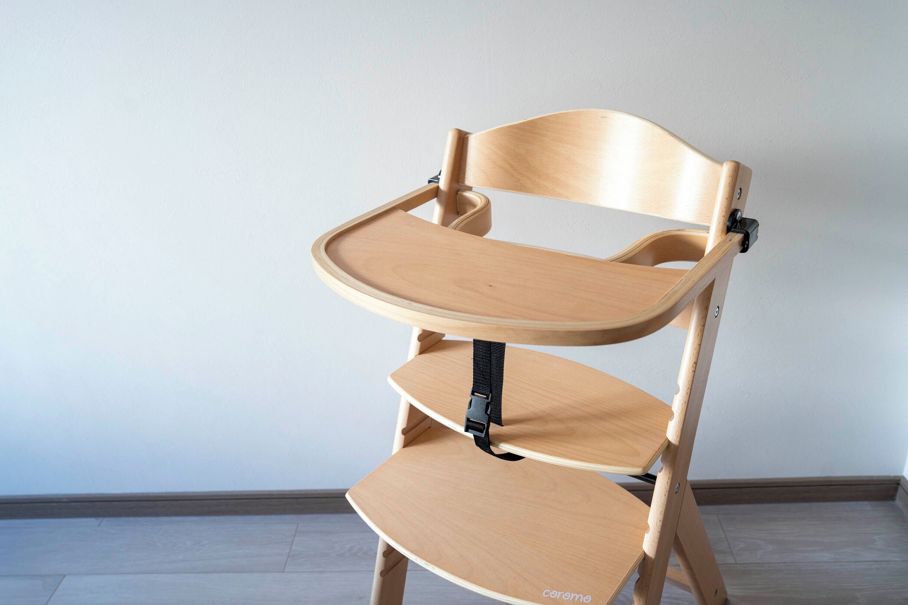 Una silla de madera con una bandeja fijada al respaldo.