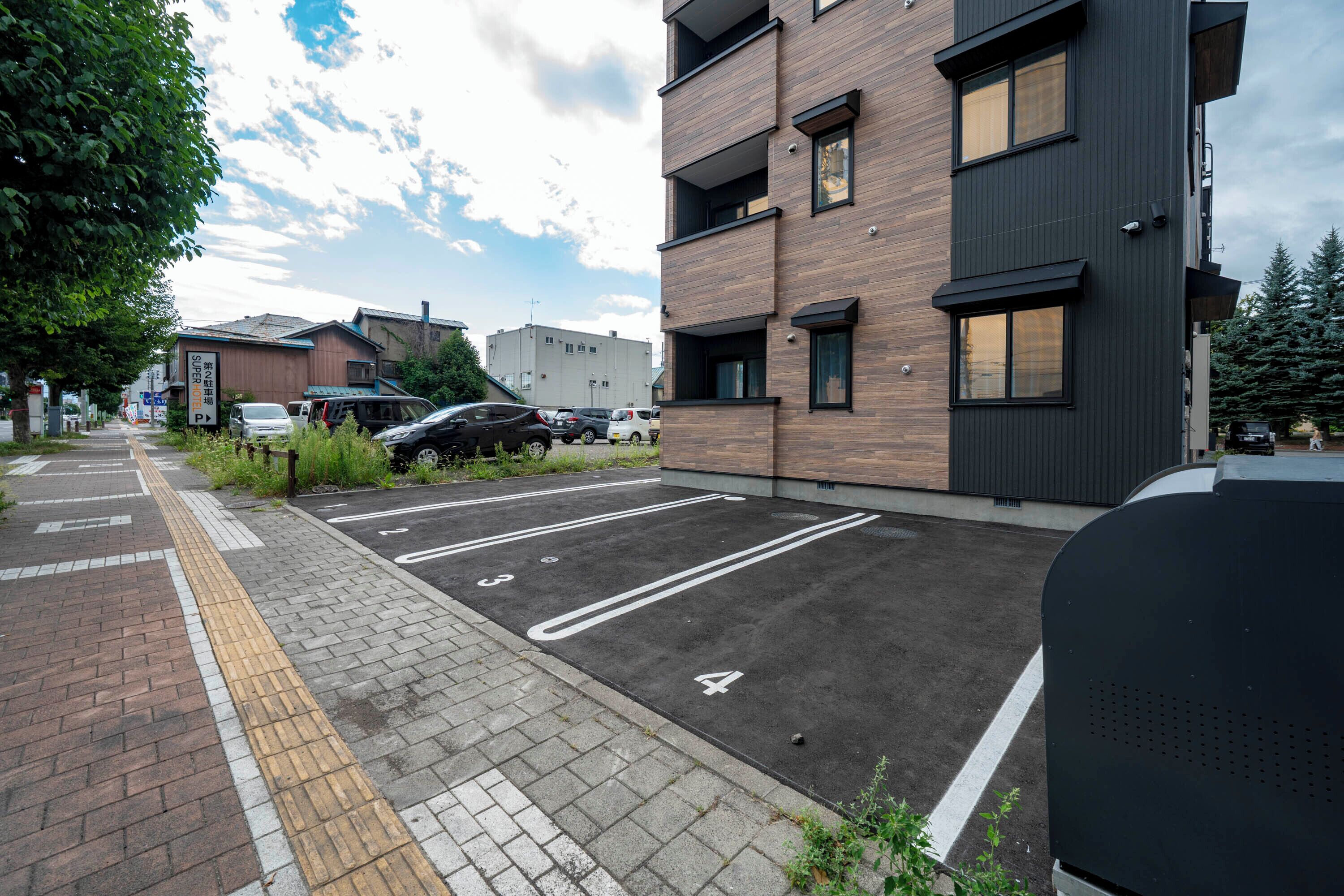 Un parcheggio con posti auto delimitati e un edificio dal design moderno.