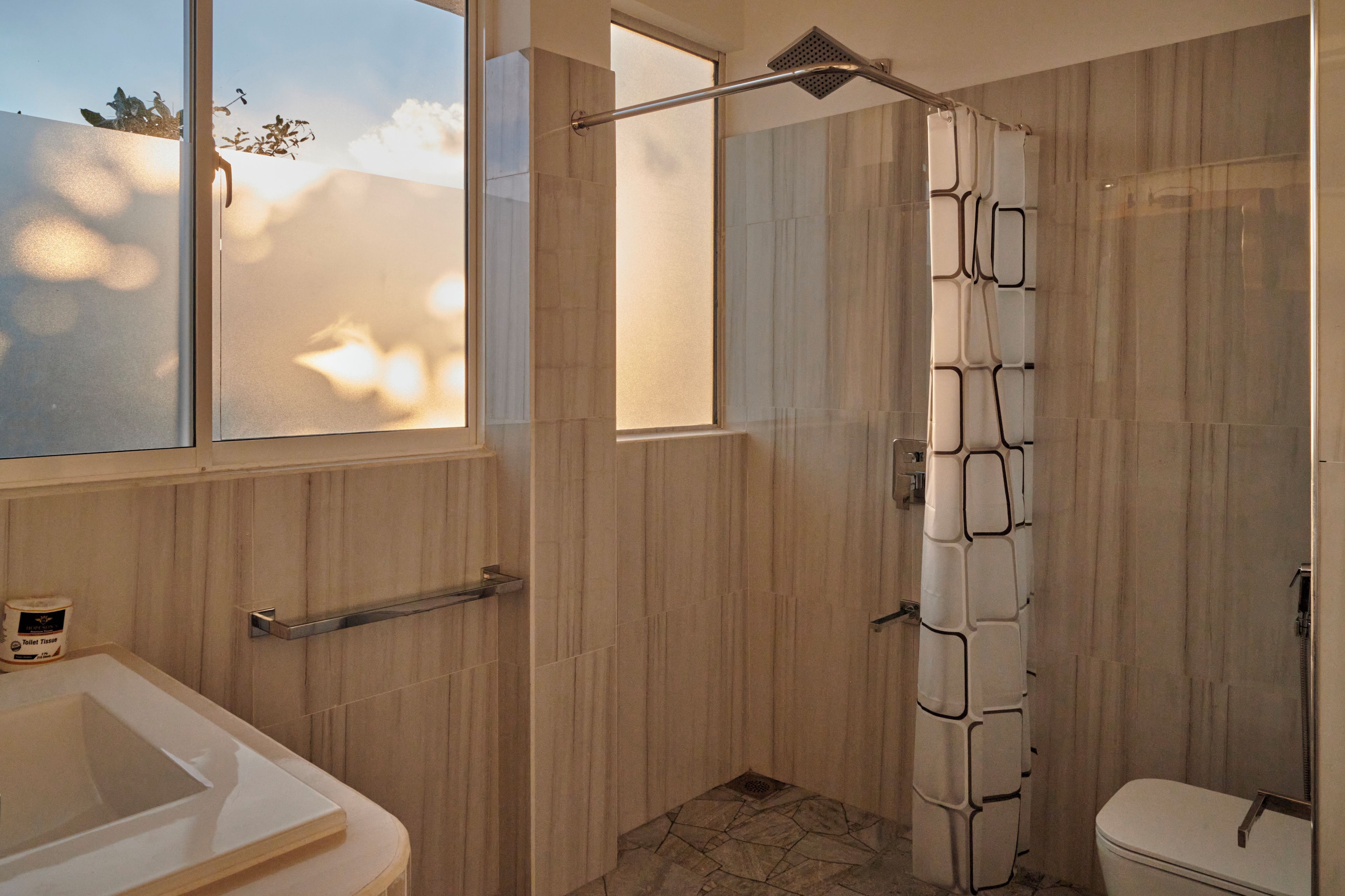 A bathroom with a shower, toilet, and sink.