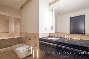 Une salle de bain moderne équipée d’une baignoire, de toilettes et d’un lavabo.