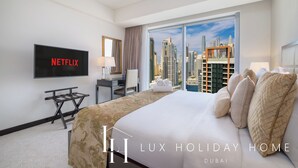 Une chambre d’hôtel avec un grand lit, un bureau, une télévision et une vue sur la ville.