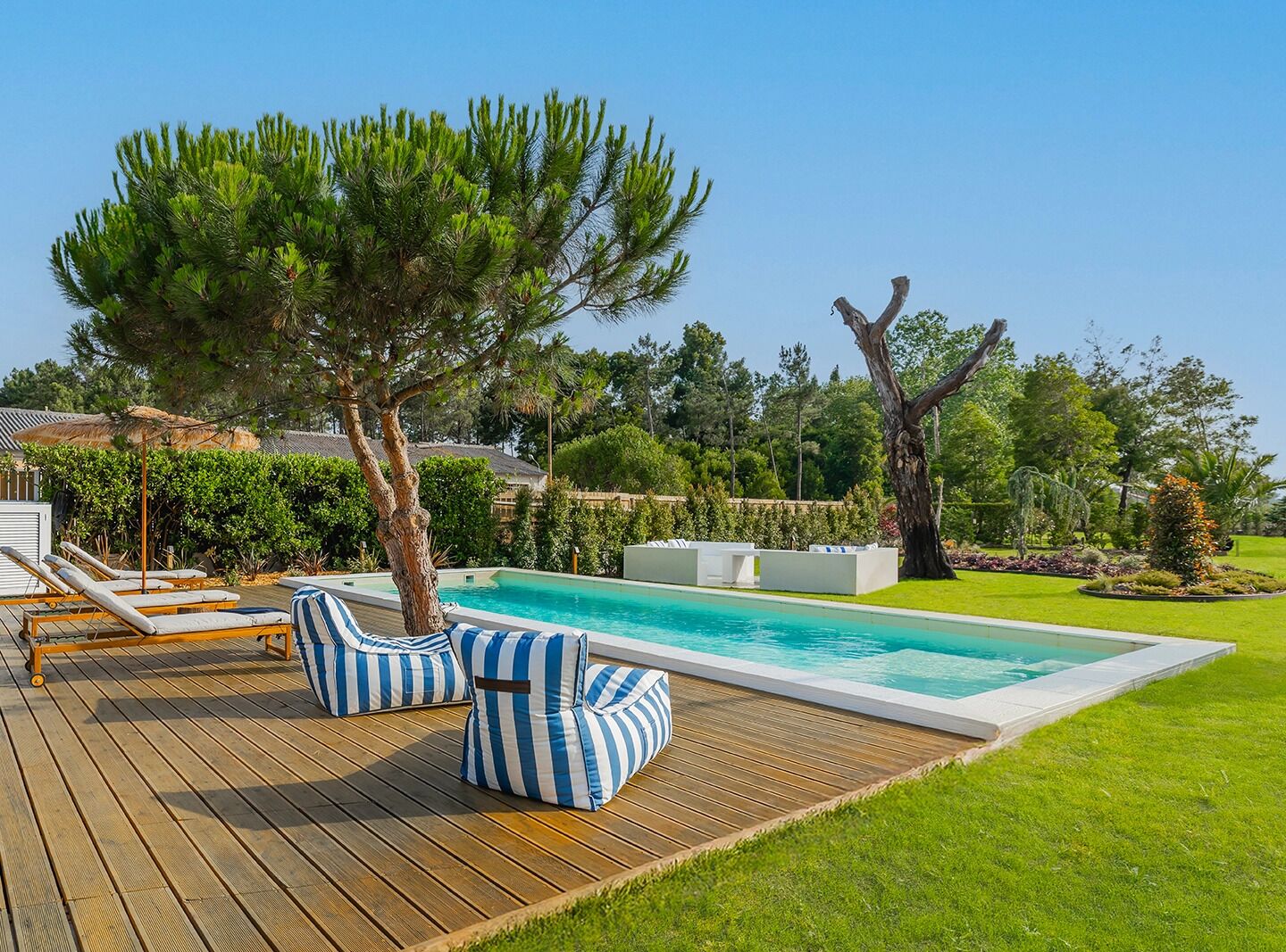 A poolside area with lounge chairs and a wooden deck.
