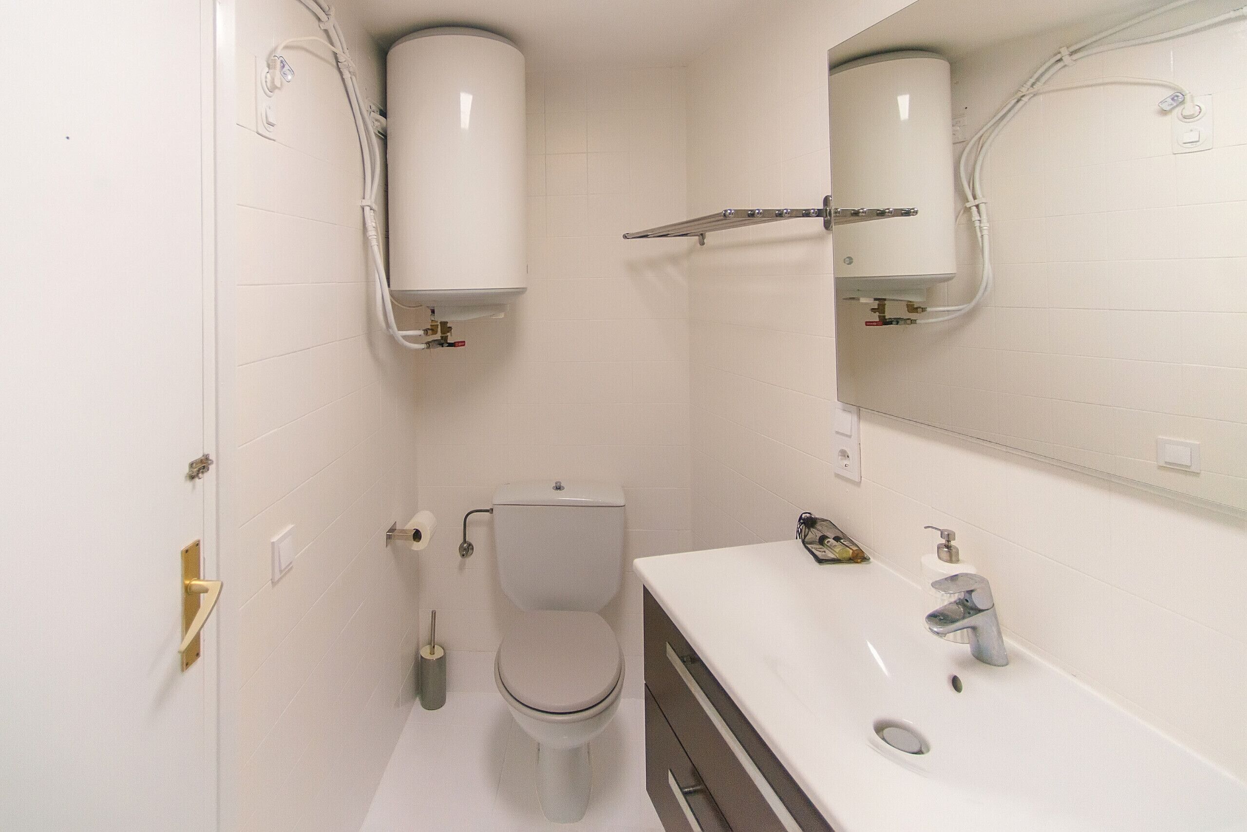 Une salle de bain moderne avec des toilettes, un lavabo et un miroir.