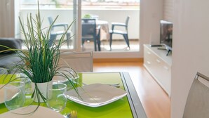 A dining area with a green table, white plates, and a potted plant. - WELCS APARTMENT 287 EMP with public swimming pool (Rosas / Roses)