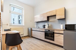 A modern kitchen with wooden cabinets, a dishwasher, an oven, and a refrigerator.