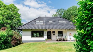 A house with a tiled roof, large windows, and a front porch with outdoor seating. - Holiday Home 'Seeblick' with Sea View, Private Terrace and Wi-Fi (Langballig)