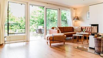 Ein modernes Wohnzimmer mit einer Couch, einem kleinen Tisch und einem Fernseher.