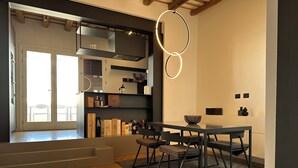 A modern kitchen with a dining area, wooden flooring, and a view to the outside. - Gonia Residence (Trapani)