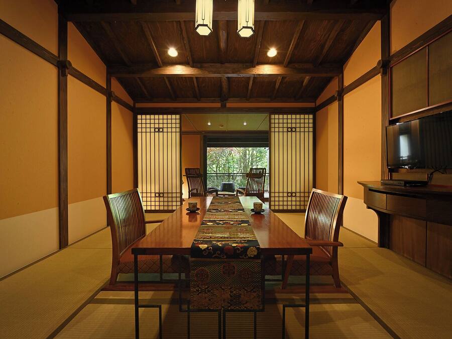 Un comedor tradicional japonés con suelo de tatami, una mesa baja y puertas correderas shoji.