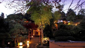 A traditional Japanese-style building with a wooden entrance and a covered walkway leading to the main building.