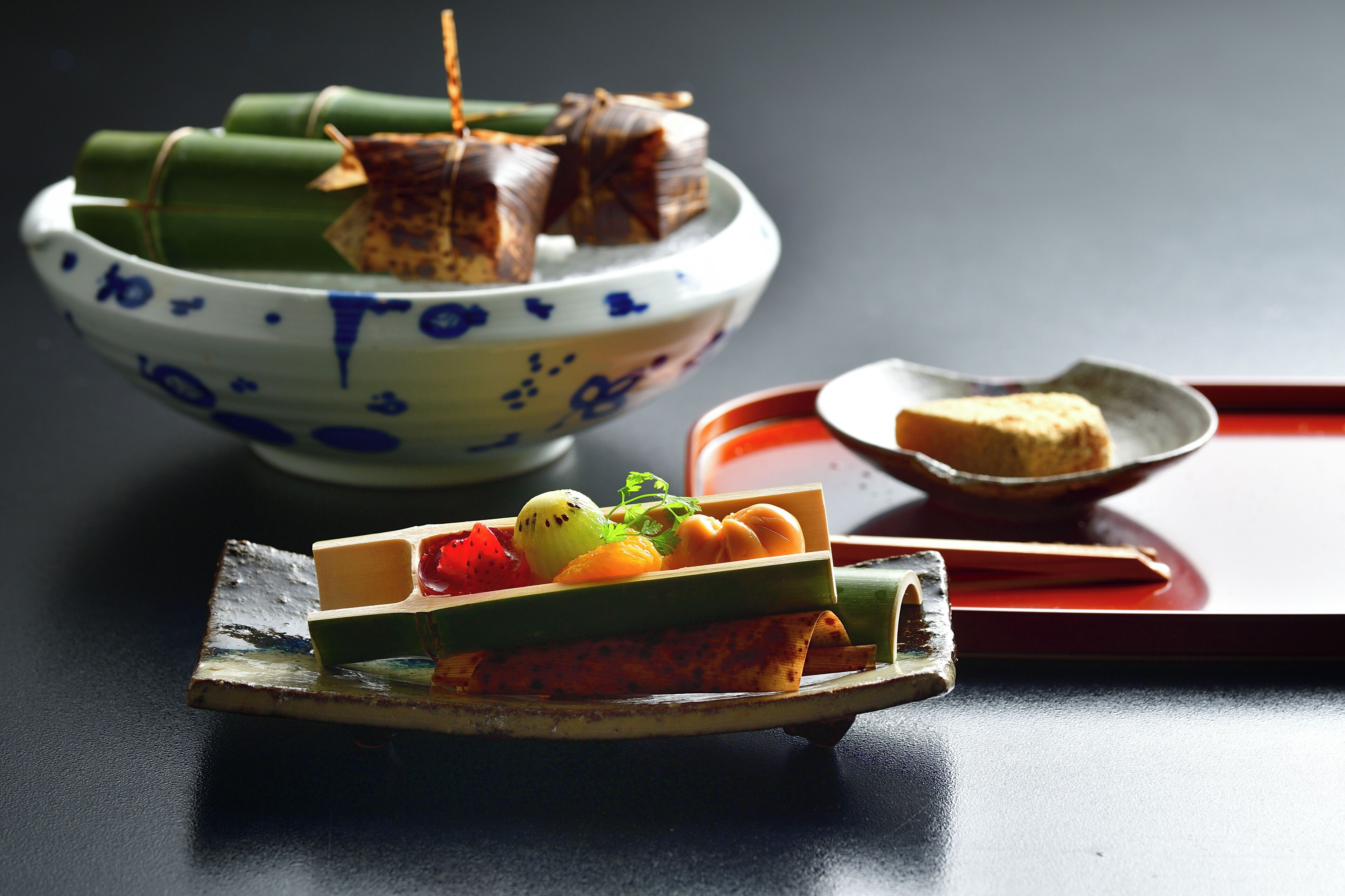 A traditional Japanese meal setup with a bowl of sushi and a plate of sashimi.