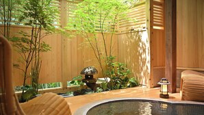 A traditional Japanese-style room with a wooden interior, a stone lantern, and a small water feature.