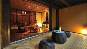 A traditional Japanese room with tatami flooring, a low table, and seating.