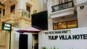 Exterior del Hotel Tulip Villa, con un cartel que indica su dirección.