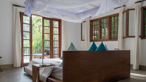 A room with a bed, a desk, and large windows with curtains. - Marula House 3BD, Diani Beach (Diani Beach)