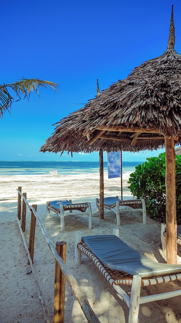 Privatstrand in der Nähe, weißer Sandstrand, Liegestühle, Sonnenschirme