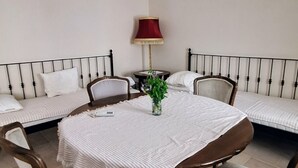 Une pièce avec une table ronde, deux canapés, une lampe et un vase rempli de fleurs.