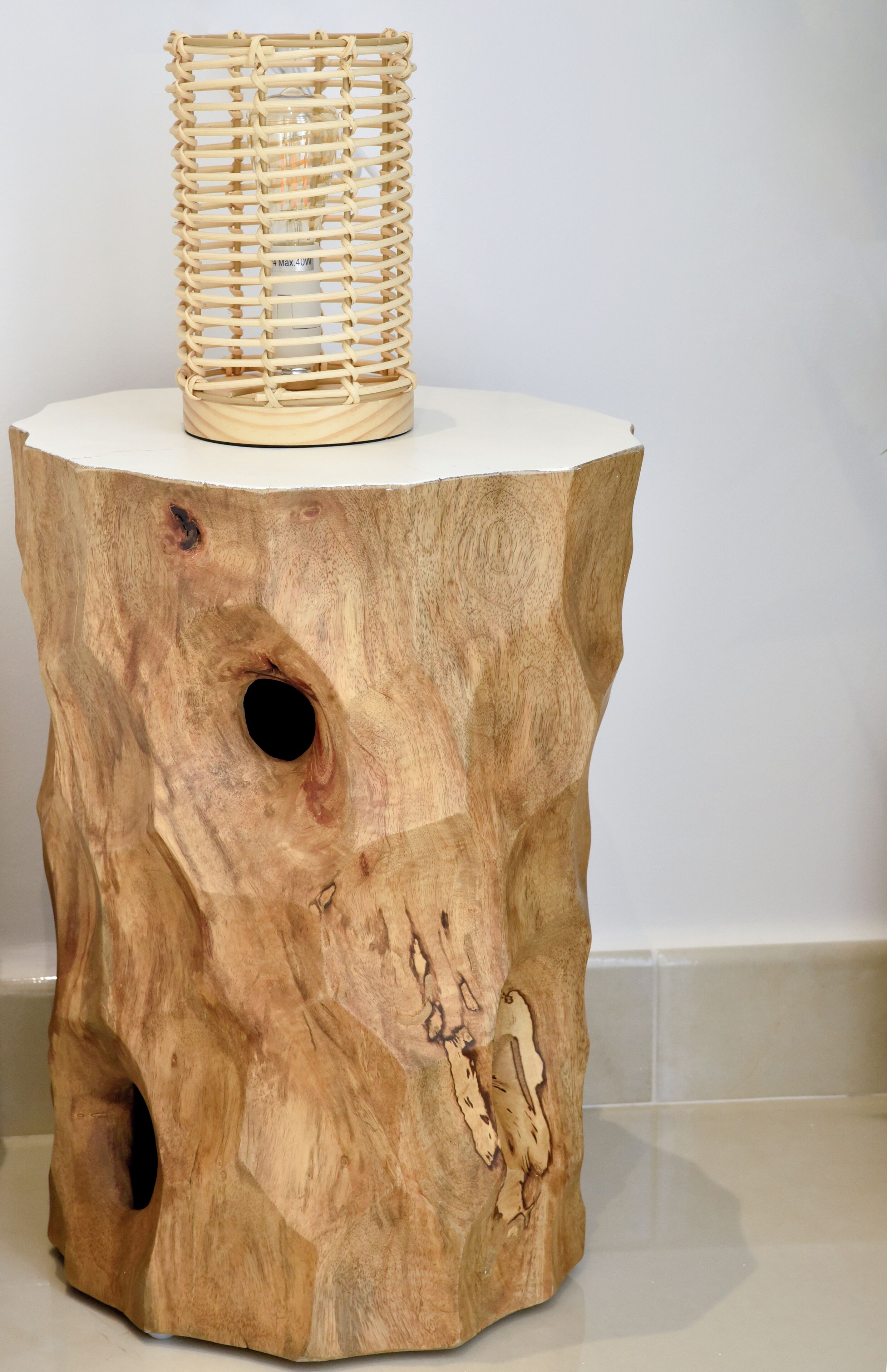 Una mesita redonda de madera con una cesta tejida encima.