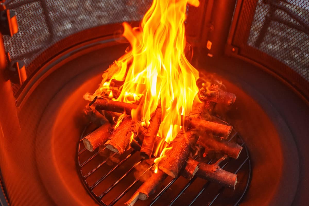 A fire pit with burning logs and flames.