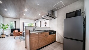 A modern kitchen with a built-in island, stainless steel appliances, and a large refrigerator. - MKS201 (Asahikawa)