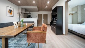 A modern, compact living space with a dining area, kitchenette, and a bedroom. - MKS201 (Asahikawa)