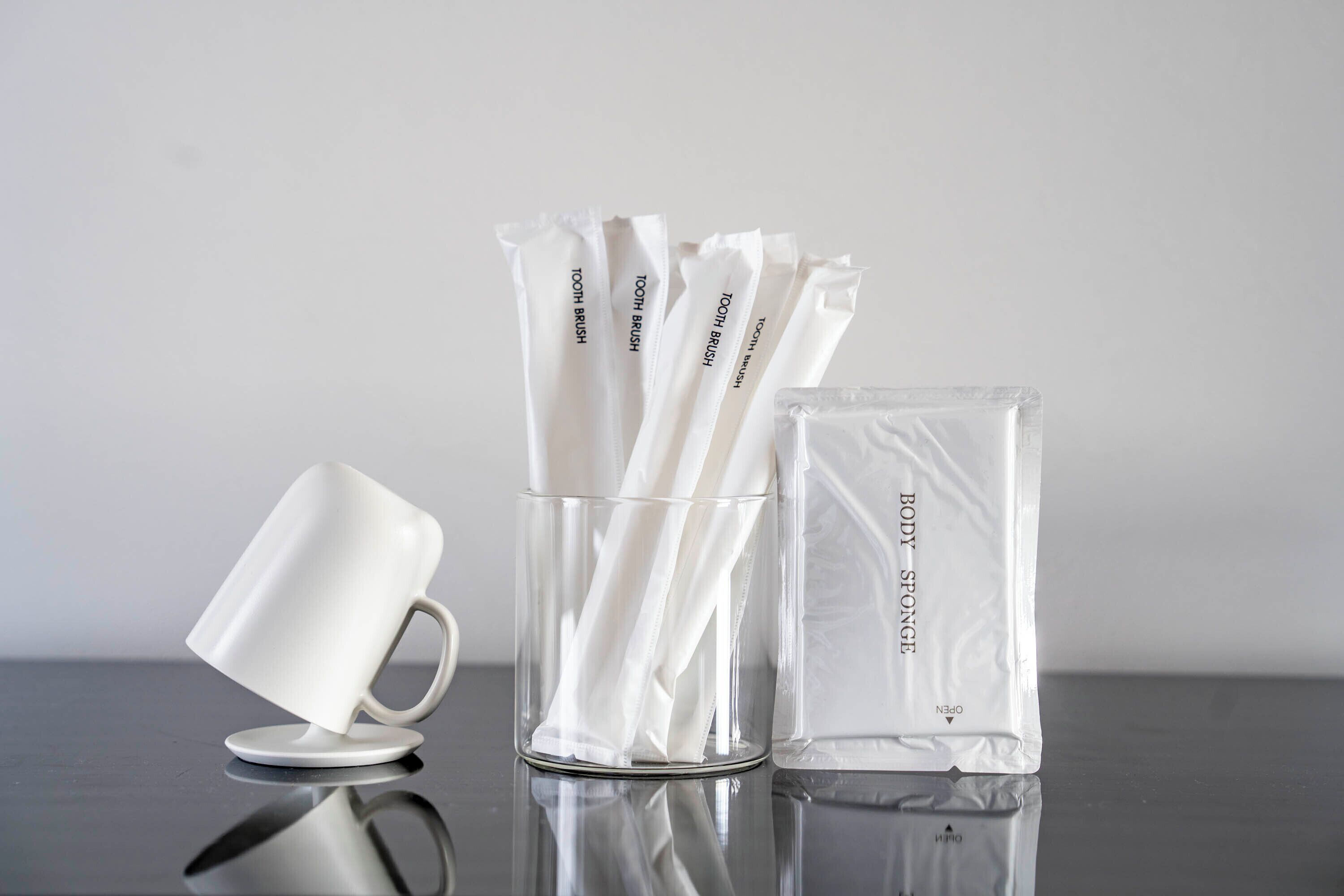 Un vaso transparente, un recipiente de vidrio con elementos blancos y un recipiente de plástico transparente con una etiqueta.