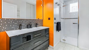 A bathroom with a large mirror, a white sink, and a glass-enclosed shower. - Villa Safari Golf & Spa - Toulouse - prox. Airbus (Plaisance-du-Touch)